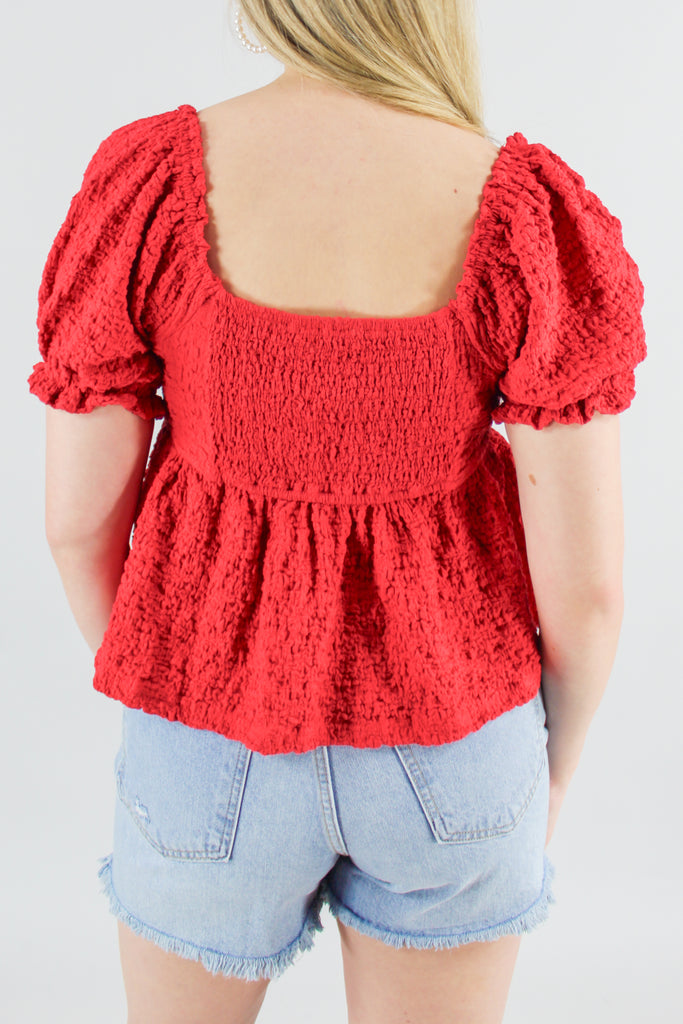 Back view of red textured babydoll top