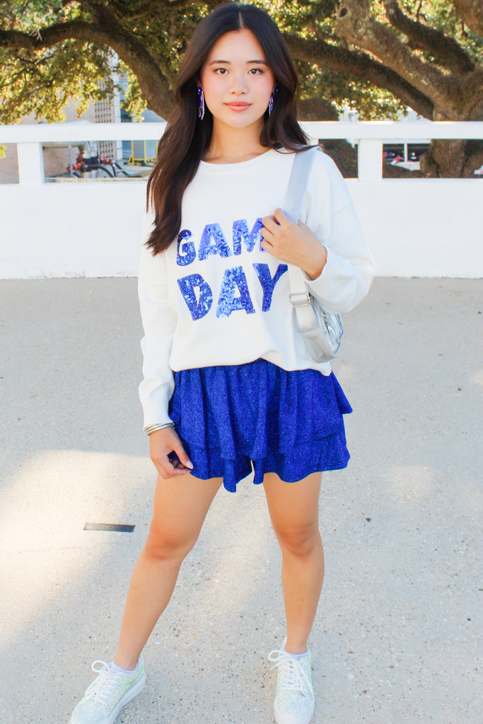 White sweater with sequin gameday in block royal letters on the front