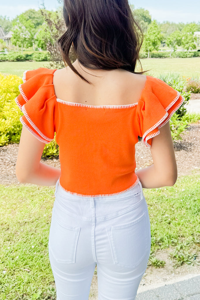 orange knit cropped tank with white exposed stitching 