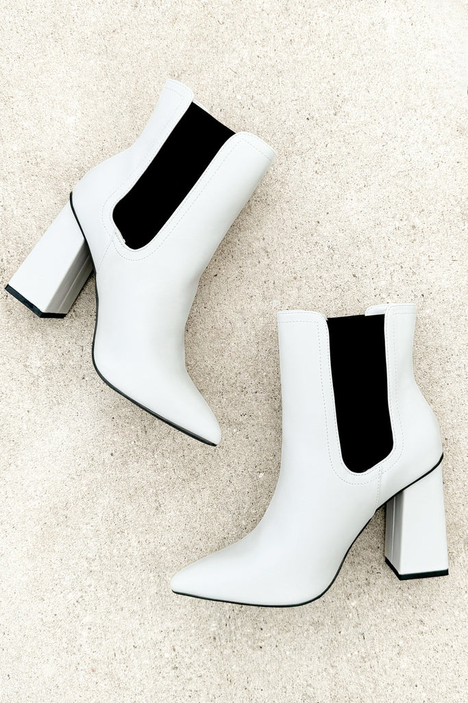 white pleather pointed toe ankle booties with a black stretchy contrast band