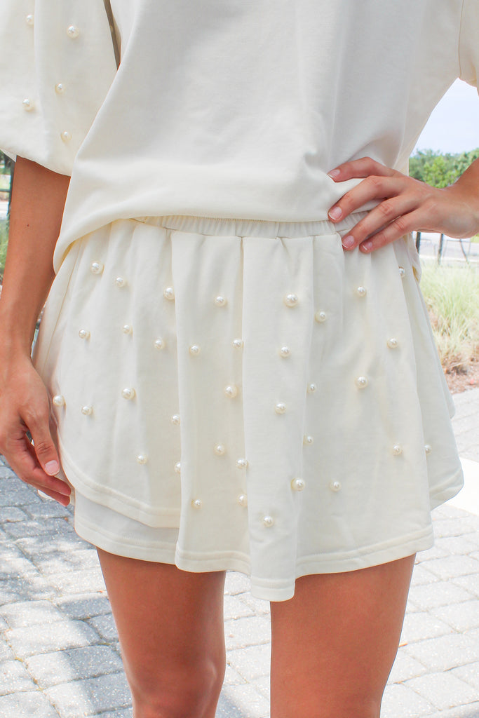 cream pearl stud skort with a smocked waist and skirt overlay