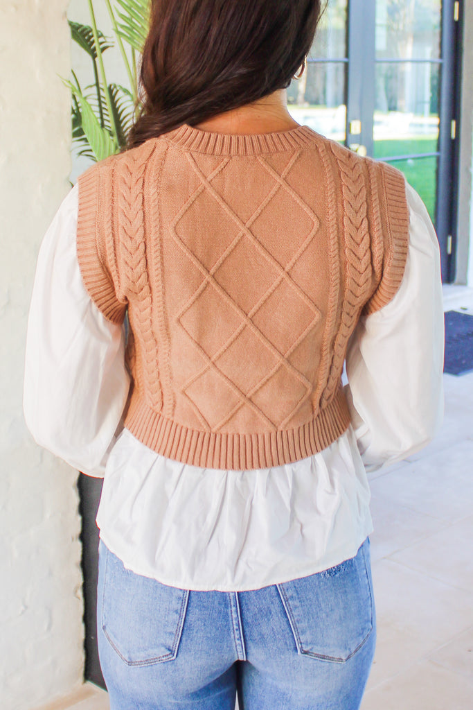 back of layered knit vest with a white button down blouse underneath 